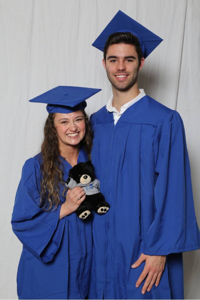 girl and guy graduate with teddy bear